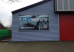 Buisframe en spandoek gemonteerd op bedrijfspand